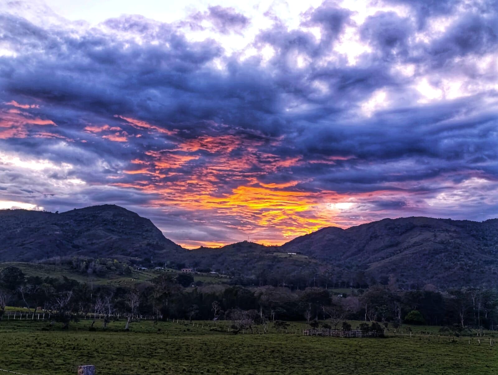 Atardecer sobre las montañas y potreros del territorio cafetero