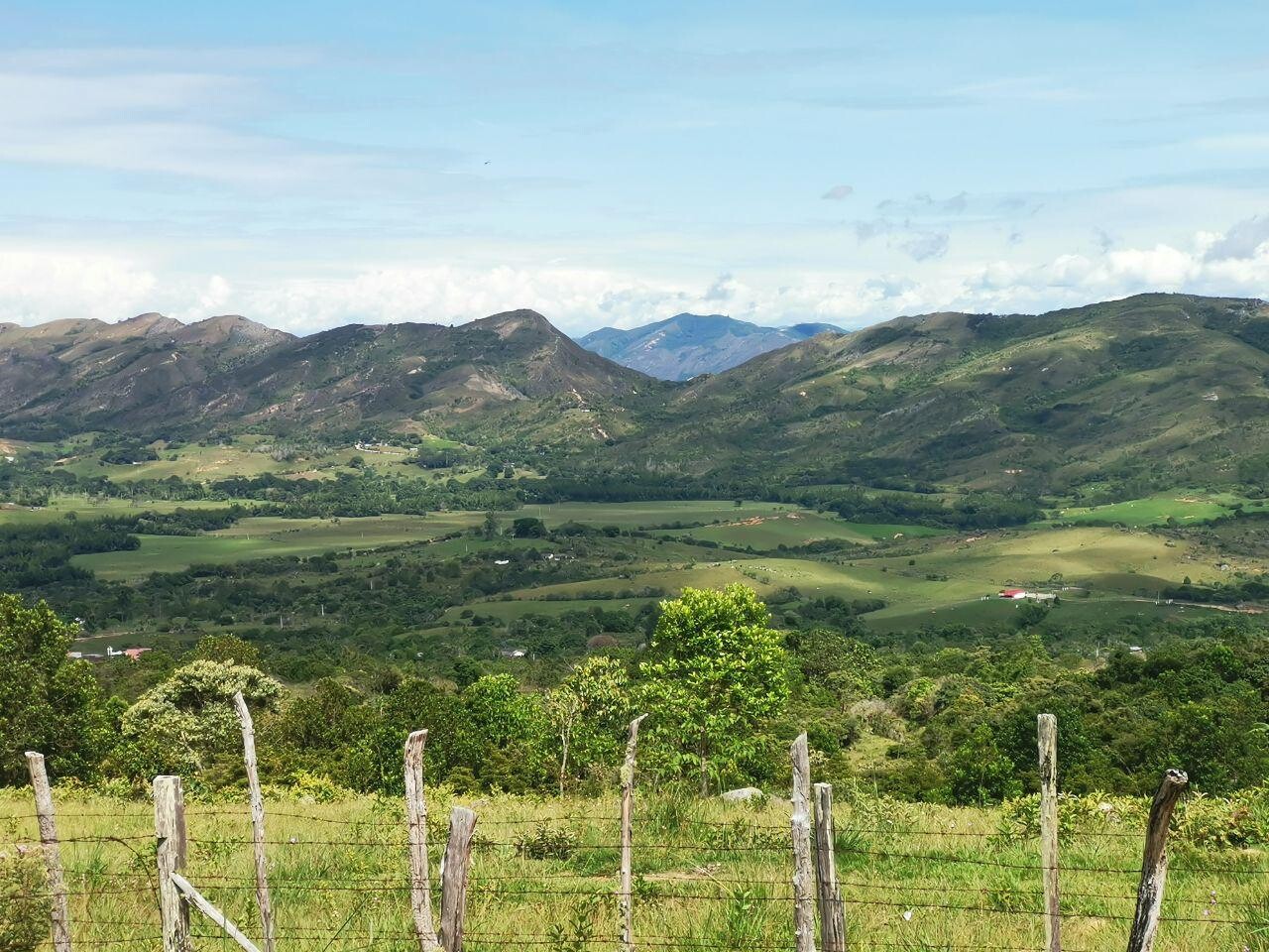 Valle verde rodeado de montañas y cercas rurales